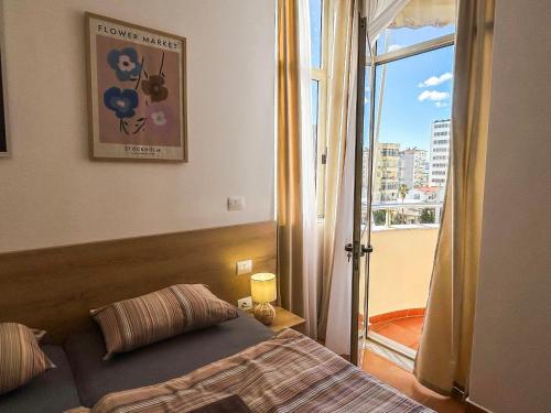 Schlafzimmer mit einem Bett und einer Tür zu einem Balkon in der Unterkunft Vacation 988 in Durrës