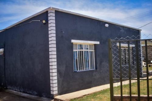 une maison bleue avec une clôture devant elle dans l'établissement Mella Homes Limuru, à Kiambu