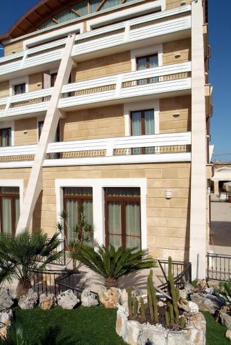 a building with a garden in front of it at UNICO Albatres Palace Salento by Life Resorts in San Vito dei Normanni