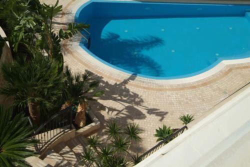 an overhead view of a swimming pool with palm trees at UNICO Albatres Palace Salento by Life Resorts in San Vito dei Normanni