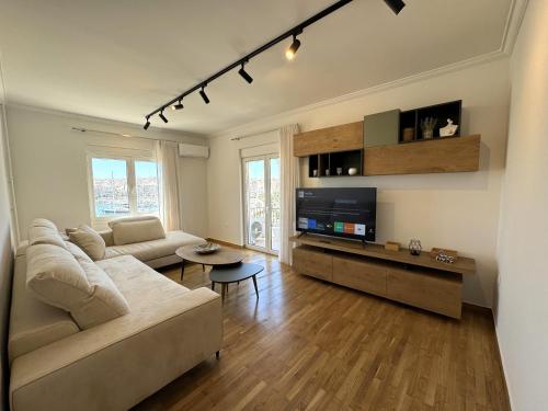 uma sala de estar com um sofá e uma televisão em Piraeus center sea view apartment em Piraeus