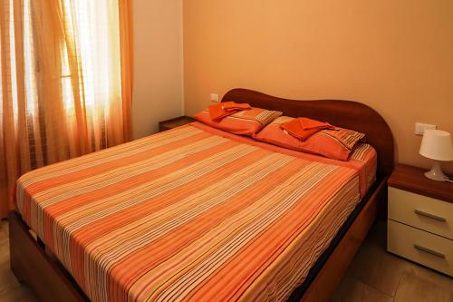 サン・ヴィート・ロ・カーポにあるCASA "MARE BLU"のベッドルーム1室(オレンジのシーツとオレンジの枕が備わるベッド1台付)
