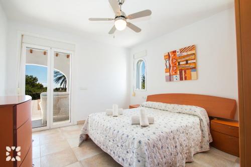 1 dormitorio con 1 cama y ventilador de techo en Villa Soleada by Abahana Villas, en Calpe