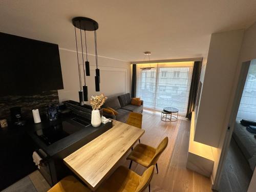 un salon avec une table et un canapé dans l'établissement Elegant Apartment Minutes from Paris, à Issy-les-Moulineaux