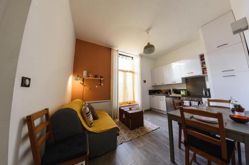 un salon avec une table et une cuisine dans l'établissement Proche centre, 2 couchages, calme, lumineux, à Amiens
