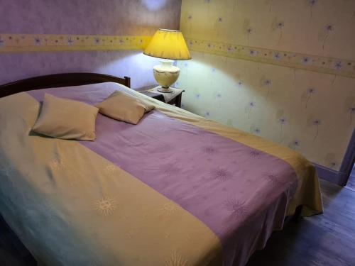 une chambre avec un lit avec une lampe sur une table dans l'établissement Maison dans le Sancy, à Le Vernet-Sainte-Marguerite