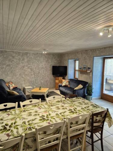 une chambre avec une table et des chaises ainsi qu'un salon dans l'établissement Maison dans le Sancy, à Le Vernet-Sainte-Marguerite