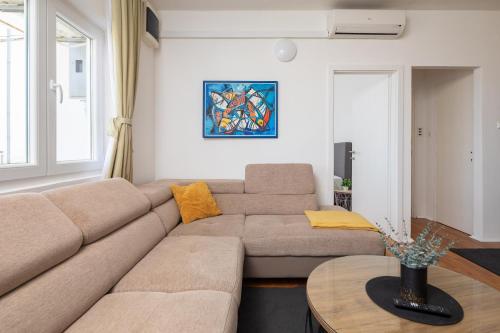 a living room with a couch and a table at Family Beach Rooms in Omiš