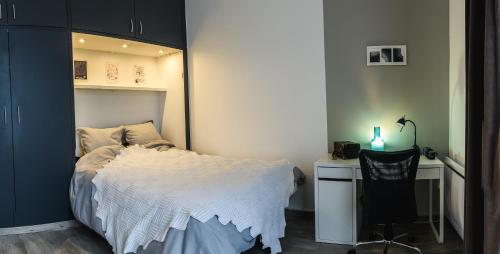 une chambre avec un lit et un bureau avec une chaise dans l'établissement Proche centre, 2 couchages, calme, lumineux, à Amiens
