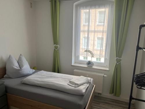 a small bed in a room with a window at Gästehaus Graupner-Mittweida in Mittweida