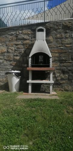 an outdoor oven in a yard with a stone wall at Villa Sumbilla, Modern, with sauna, heated jacuzzi near Tuscany in Monghidoro