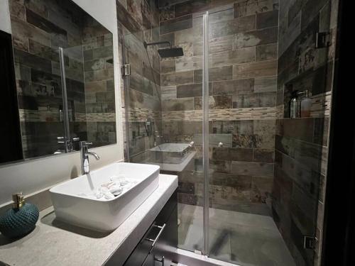a bathroom with a sink and a glass shower at Casa de lujo Altozano Residencial con Piscina by AIRA 