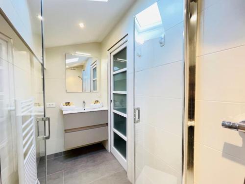 une salle de bain avec une douche en verre et un lavabo dans l'établissement Liberty Fréjus plage vue mer panoramique, à Fréjus