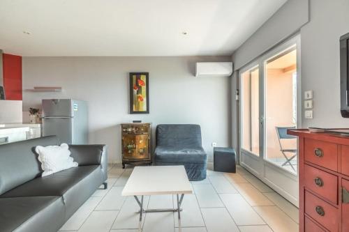 un salon avec un canapé et une chaise dans l'établissement Liberty Fréjus plage vue mer panoramique, à Fréjus