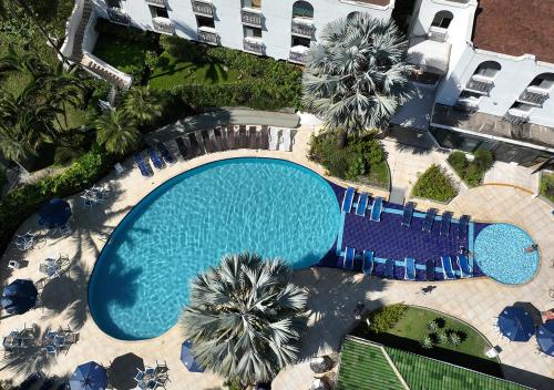 an overhead view of a swimming pool with palm trees at Wembley Inn Hotel in Ubatuba