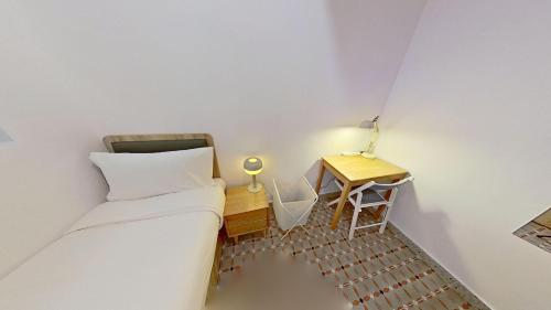 a small bedroom with a bed and a desk at Habyt Bridges - 6-8 Wa In Fong Street in Hong Kong