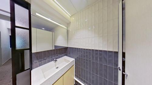 a bathroom with a sink and a mirror at Habyt Bridges - 6-8 Wa In Fong Street in Hong Kong