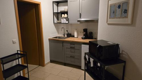 eine Küche mit einem Waschbecken und einem TV auf einem Stuhl in der Unterkunft Bei Annemarie in Trier