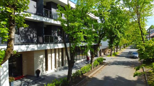 una calle vacía con árboles delante de un edificio en Ikonik Spa Hotel en Nyíregyháza