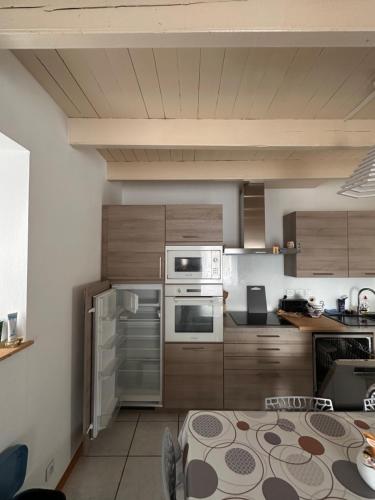 une cuisine avec des appareils en acier inoxydable et des armoires en bois dans l'établissement Maison centre bourg, à Plouha