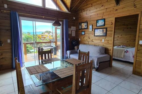 una sala da pranzo con tavolo e divano in una cabina di Moradas do Maneca a Imbituba