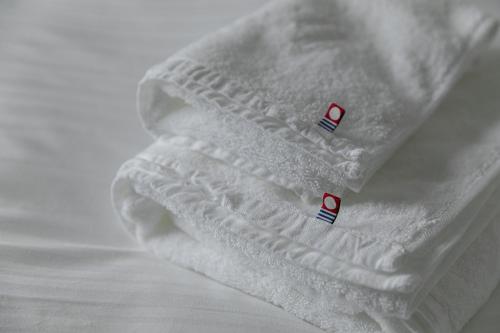 a close up of a white blanket on a bed at Shimanami PRIME HOTEL IMABARI in Imabari