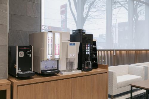 a room with several machines on a counter with a chair at Shimanami PRIME HOTEL IMABARI in Imabari