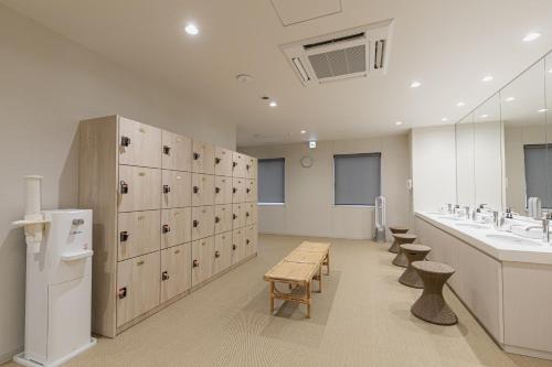 a large bathroom with a sink and a locker room at Shimanami PRIME HOTEL IMABARI in Imabari