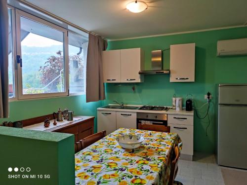 a kitchen with a table and a kitchen with green walls at Swimming and Sun in Gandosso