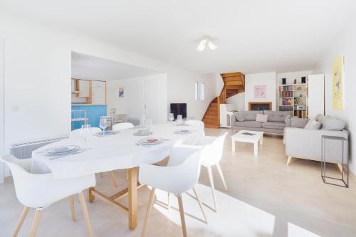 une salle à manger et un salon avec une table et des chaises blanches dans l'établissement Maison tout à pied Le Croisic, au Croisic