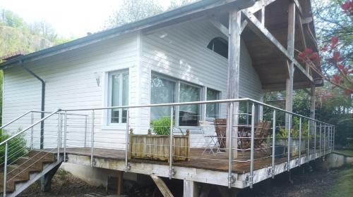 a small white house with a large deck at La Douc'Heure in Doucier