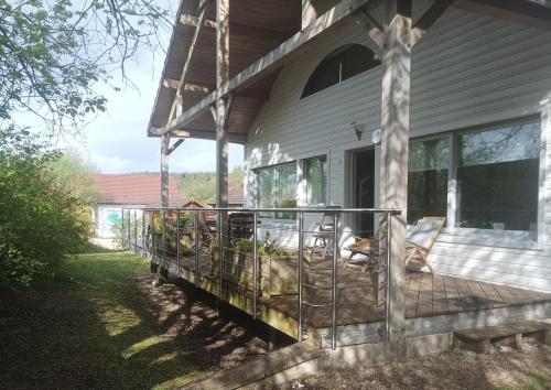 a porch of a house with chairs on it at La Douc'Heure in Doucier