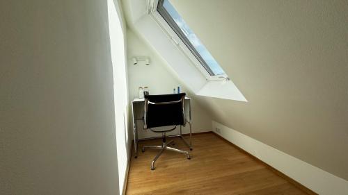 a small room with a chair and a window at City-Apartment in bester Lage in Münster