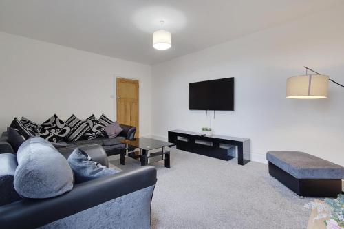 a living room with a couch and a flat screen tv at Wimbourne Road Apartment 3 in Bournemouth