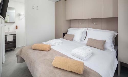 a large white bed with two towels on top of it at Aminess Style Glamping Villas & Holiday Homes Avalona in Povljana