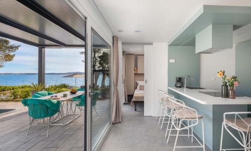 a kitchen and dining room with a view of the ocean at Aminess Style Glamping Villas & Holiday Homes Avalona in Povljana