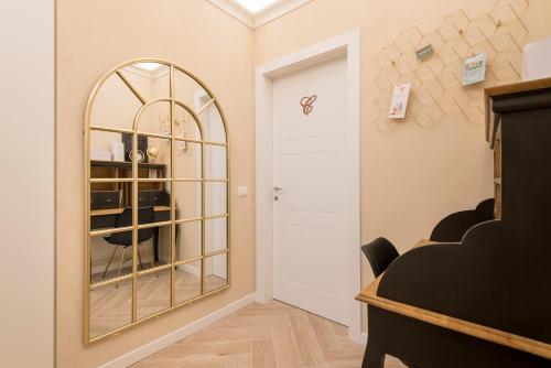 a dressing room with a mirror and a door at Golden Chic - Città Alta in Bergamo