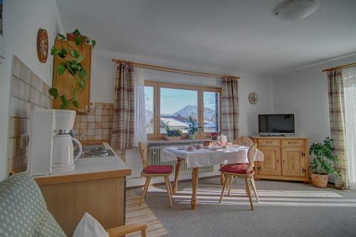 een keuken met een tafel en stoelen en een keuken met een raam bij Ferienwohnungen Mayr in Bad Wiessee