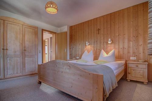 a bedroom with a large bed with a wooden wall at Ferienwohnungen Mayr in Bad Wiessee
