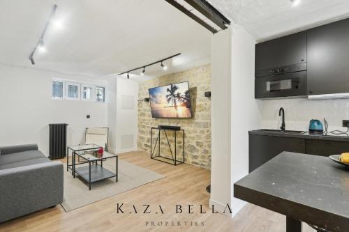 een keuken en een woonkamer met een bank en een tafel bij KAZA BELLA - Maisons Alfort 5 Luxurious apartment with private garden and Jacuzzi in Maisons-Alfort