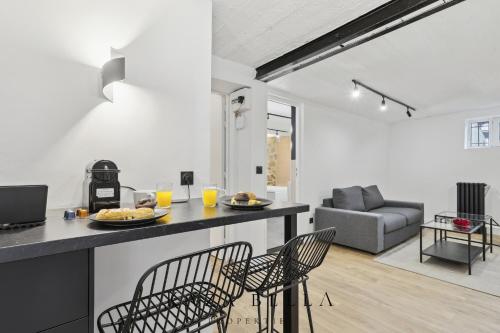 uma cozinha e sala de estar com mesa e cadeiras em KAZA BELLA - Maisons Alfort 5 Luxurious apartment with private garden and Jacuzzi em Maisons-Alfort
