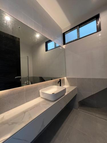 a bathroom with a sink and a mirror at The Rooftop Townhouse in Center of Pattani in Kampong Rusamileh