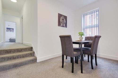 a dining room with a table and chairs and stairs at Wimbourne Road Apartment 3 in Bournemouth