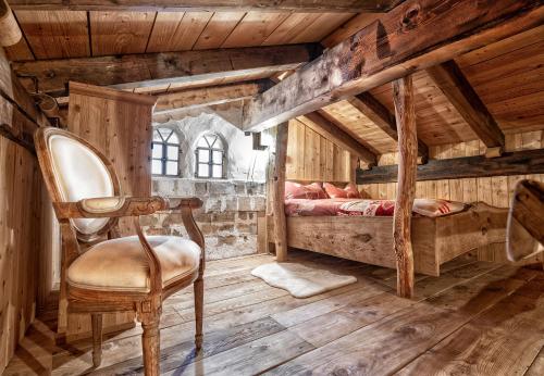 una camera da letto con una sedia in una stanza con pareti in legno di Agriturismo Randis a Piano dʼArta