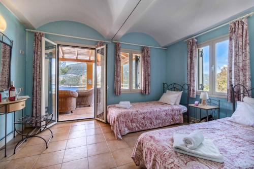 a bedroom with two beds and a balcony at Villa Elpida in Sivota