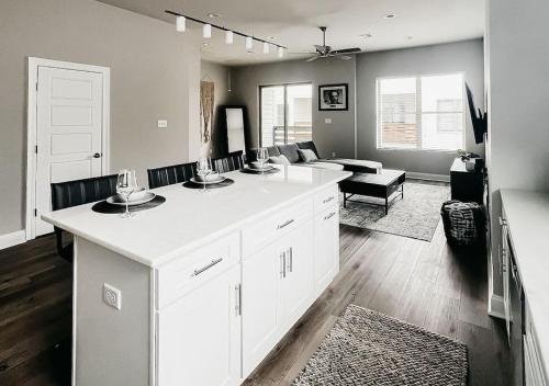 a kitchen with a white counter and a living room at New Luxury Townhome in Youngsville