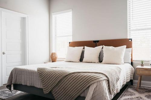 a bedroom with a large bed with white sheets and pillows at New Luxury Townhome in Youngsville