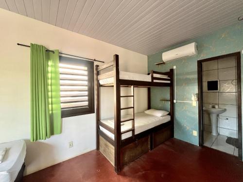a room with two bunk beds and a bathroom at No Worries Pipa in Pipa