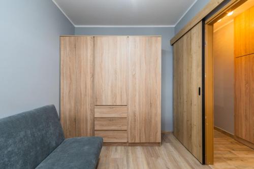 a room with a closet and a couch and a door at Fala 2 by Grand Apartments in Gdańsk