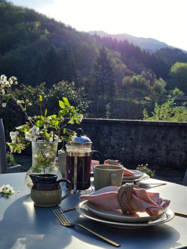 a table with plates of food and a view of a mountain at Casa di Marco in Irola